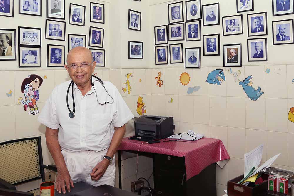 Le Dr Adenwalla dans son bureau rempli d'images de chirurgiens