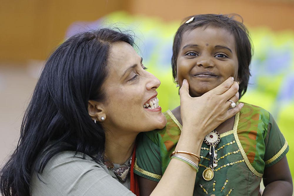 Mamta squeezes the cheek of Smile Train cleft patient