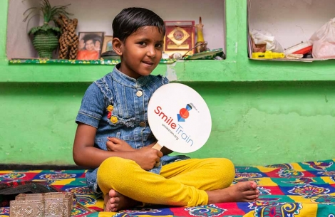 Saraswati holds a Smile Train fan